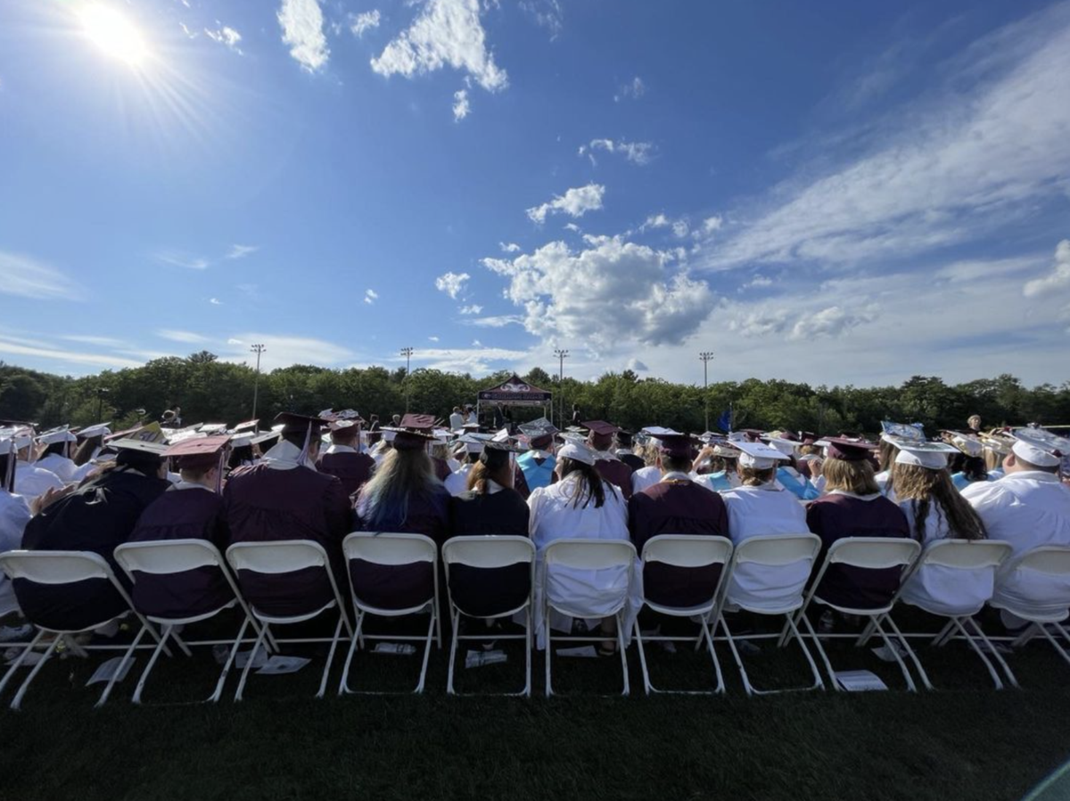 A group of people sitting in chairs in a field