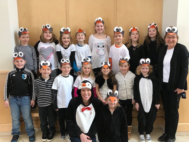 A group of children wearing adorable penguin hats, showcasing their playful and cheerful spirit.