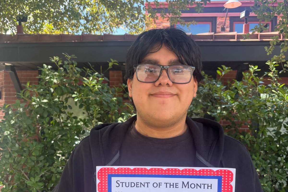 Proud student holding his student of the month certificate