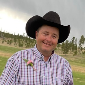 man wearing black cowboy hat and plaid shirt
