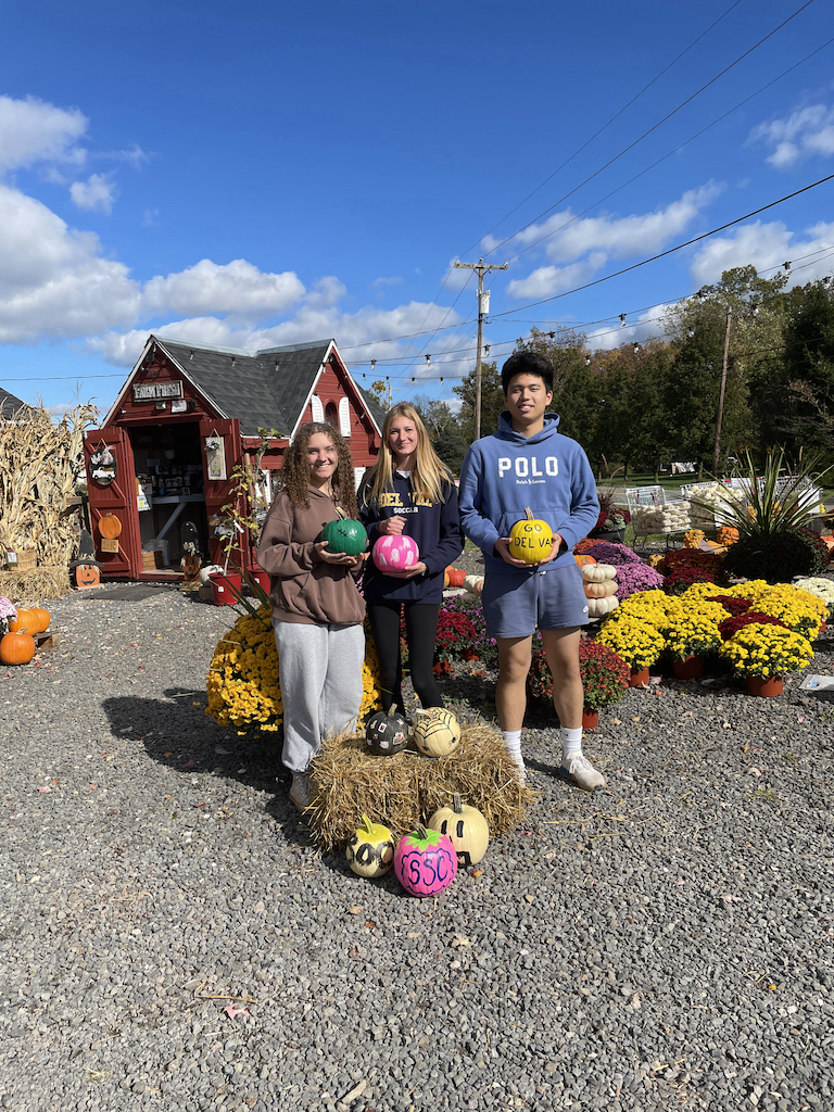 Students pose with painted pumpkins