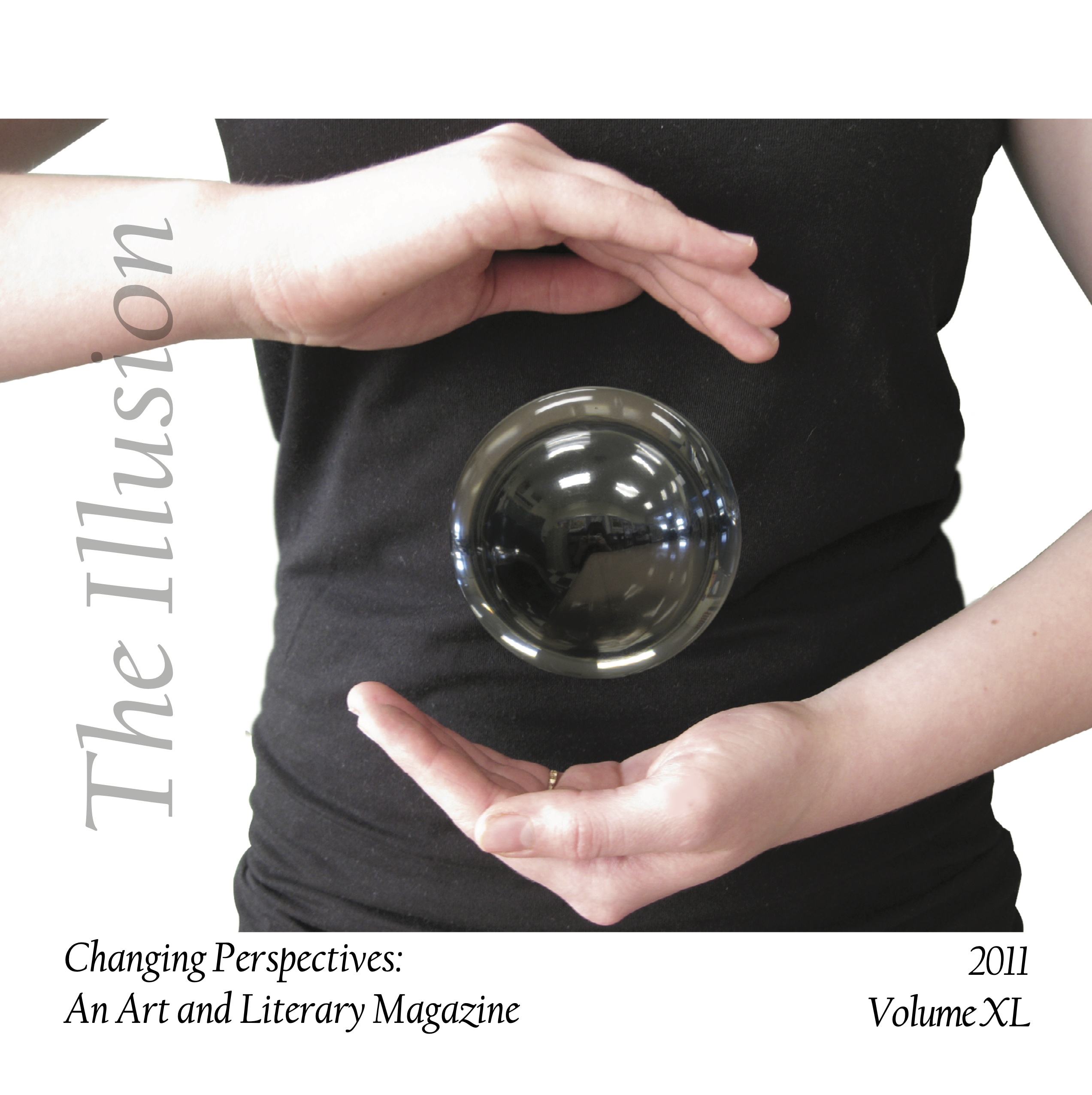 Photograph of glass sphere suspended between a magician's hands.