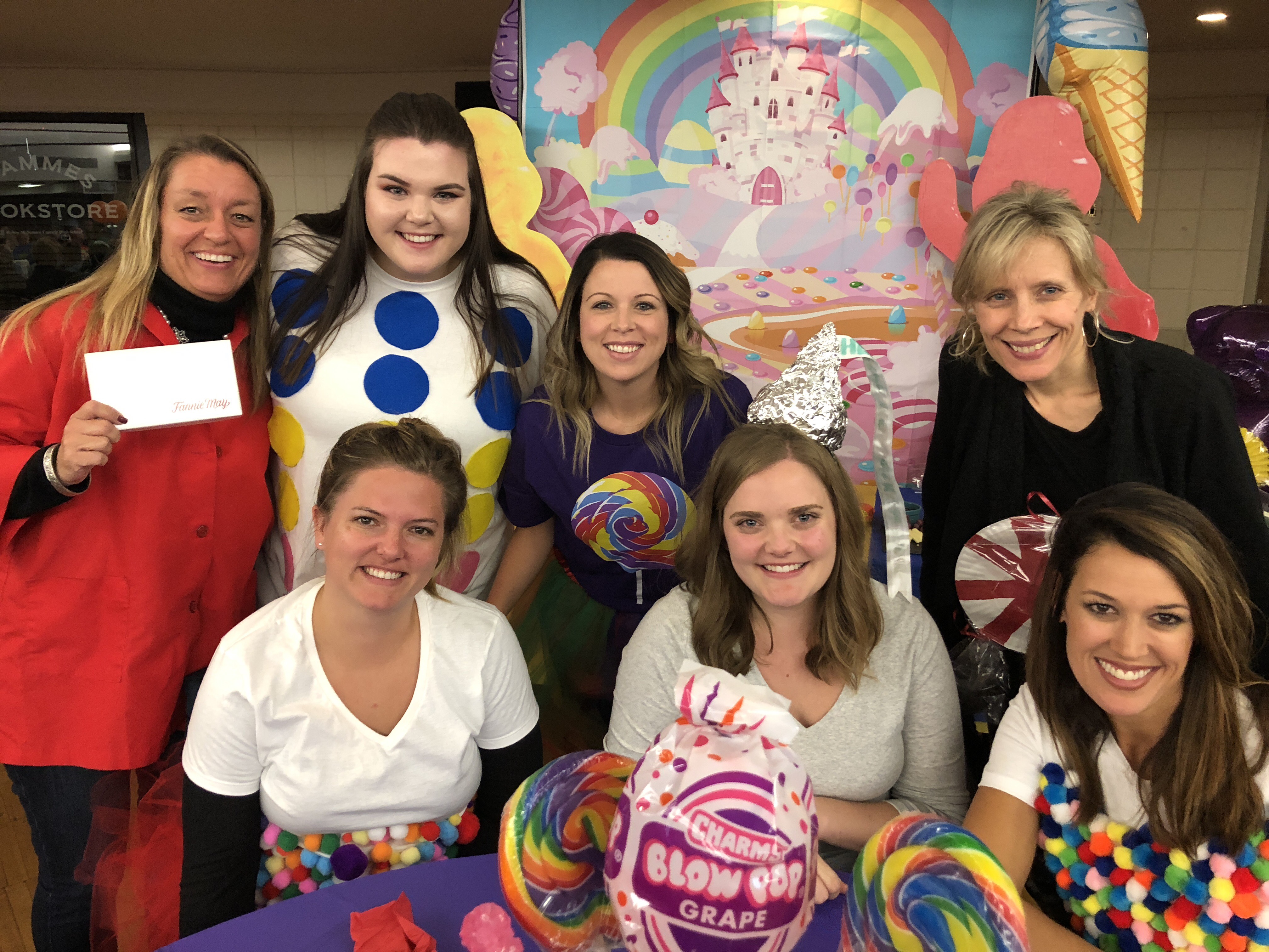 A group of 7 women holding sweets such as swirly lollipop