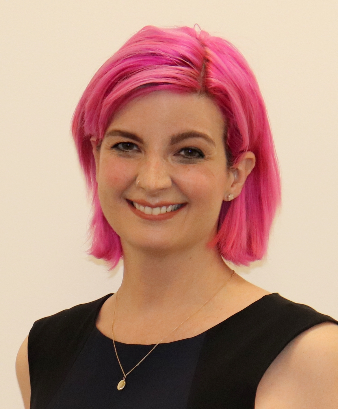 A woman with pink hair and a black top.