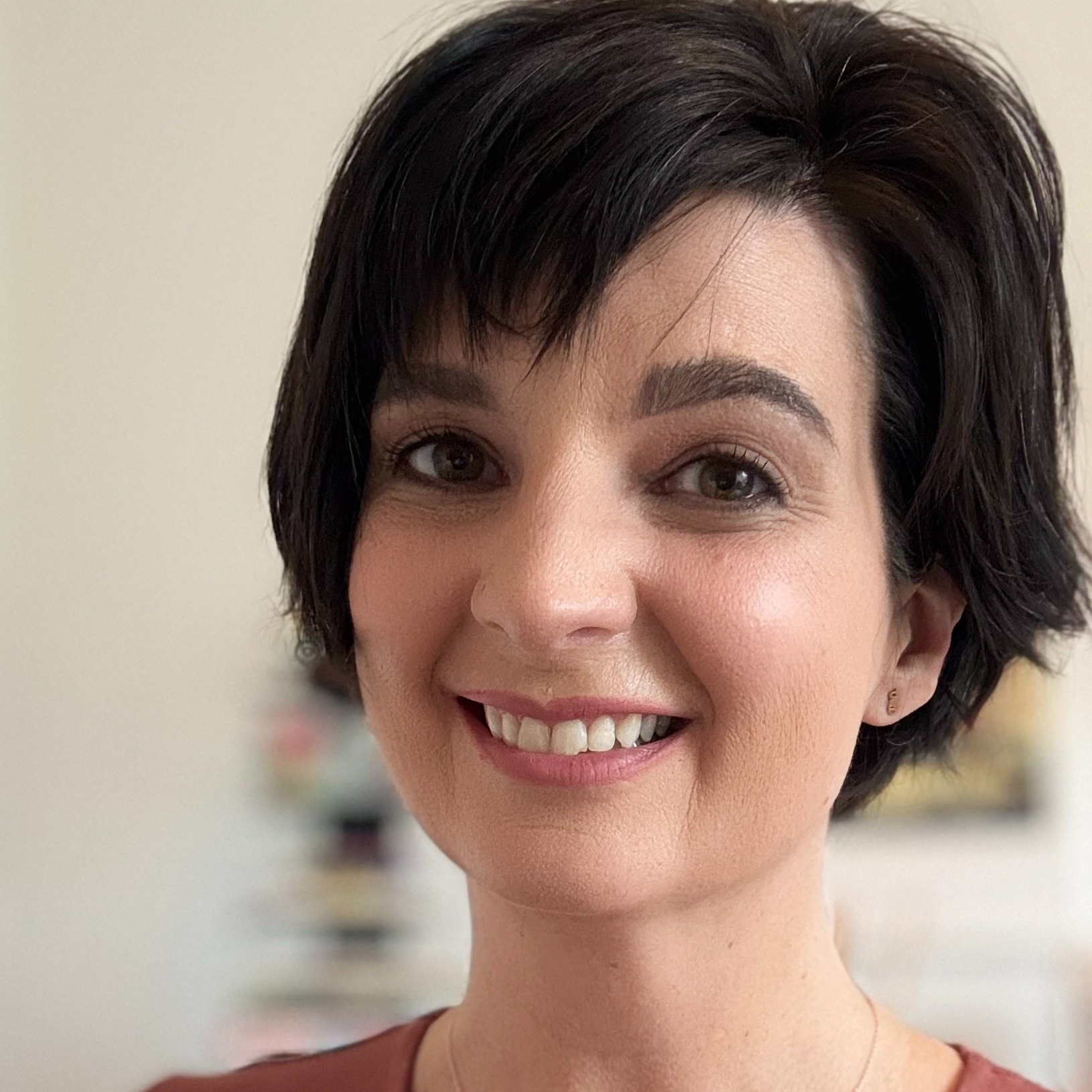 A woman with short black hair smiling at the camera