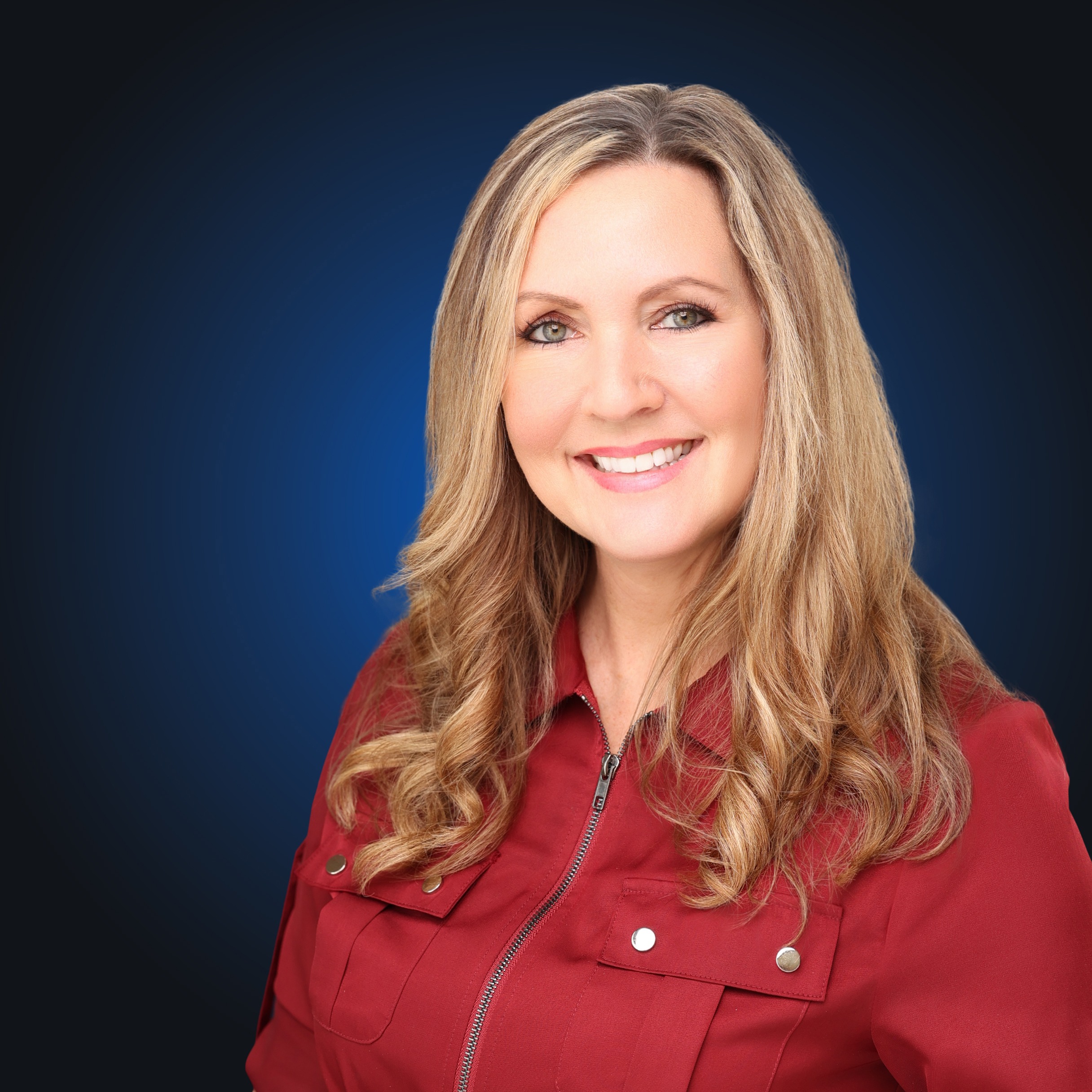 Woman with blonde hair in red zip down shirt at camera