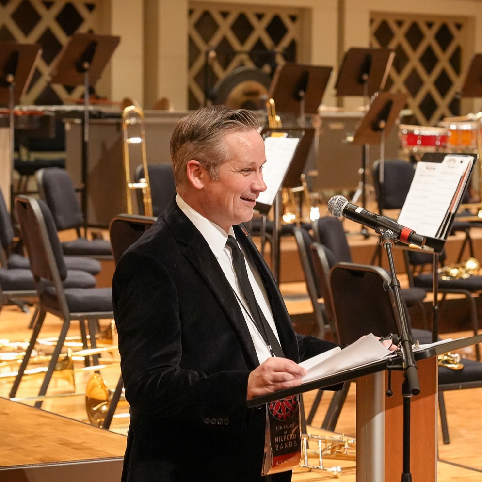 Man in suit in front of empty orchestra 