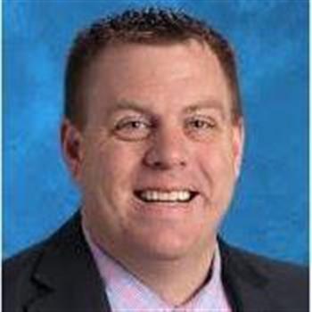 A professional man wearing a suit and tie with a pleasant expression on his face.