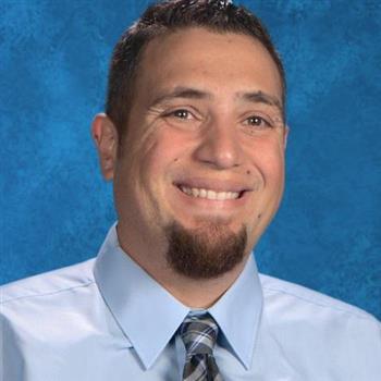 A smiling man with a beard and tie, exuding confidence and professionalism.