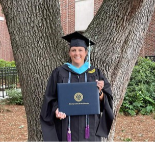 RCS Teacher holding Graduate School Diploma