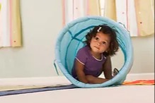 little girl playing in a tunnel on the ground