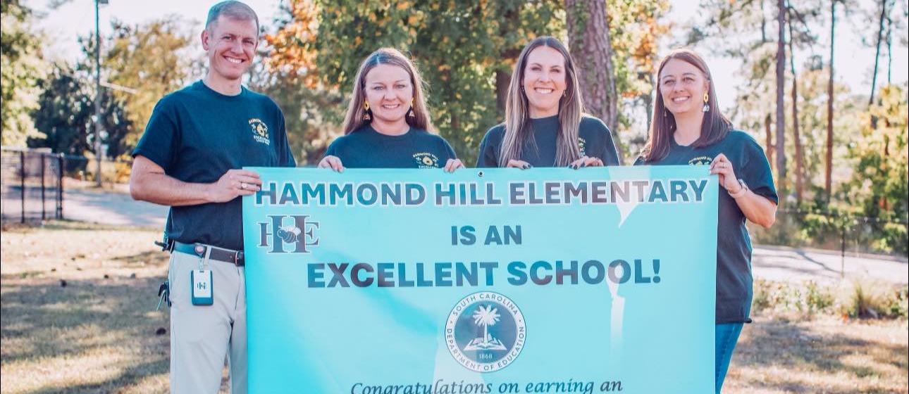 3 women and 1 man holding excellent sign