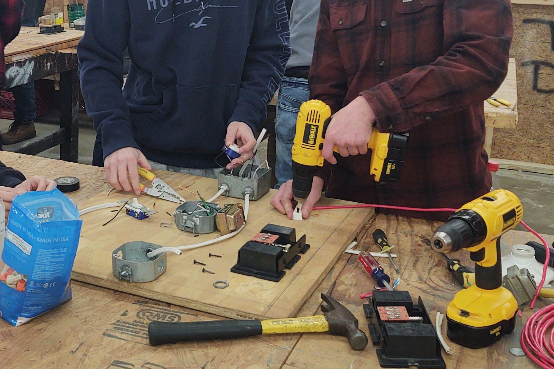 2 student's hands working on electrical board