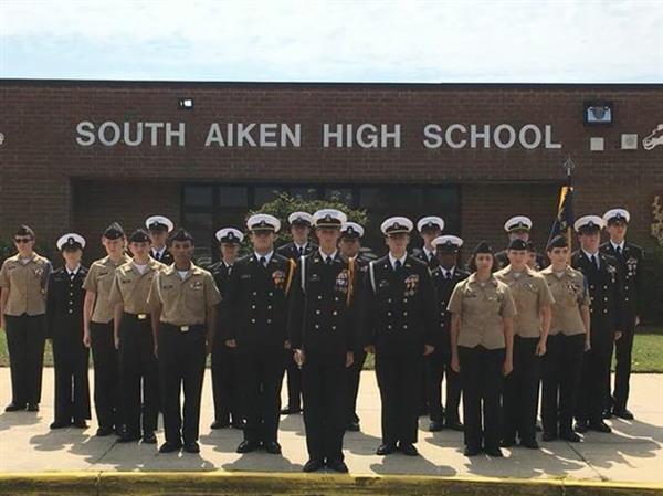 students in military uniform on front of school building