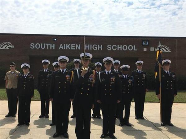 students in military uniform on front of school building