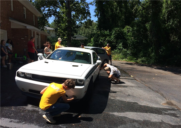 military students at activity washing a car