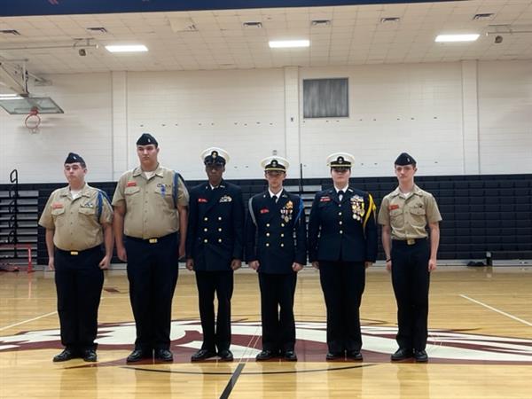 Military students posing with uniform at gym 