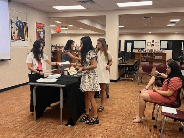 students picking up flyters and a front table