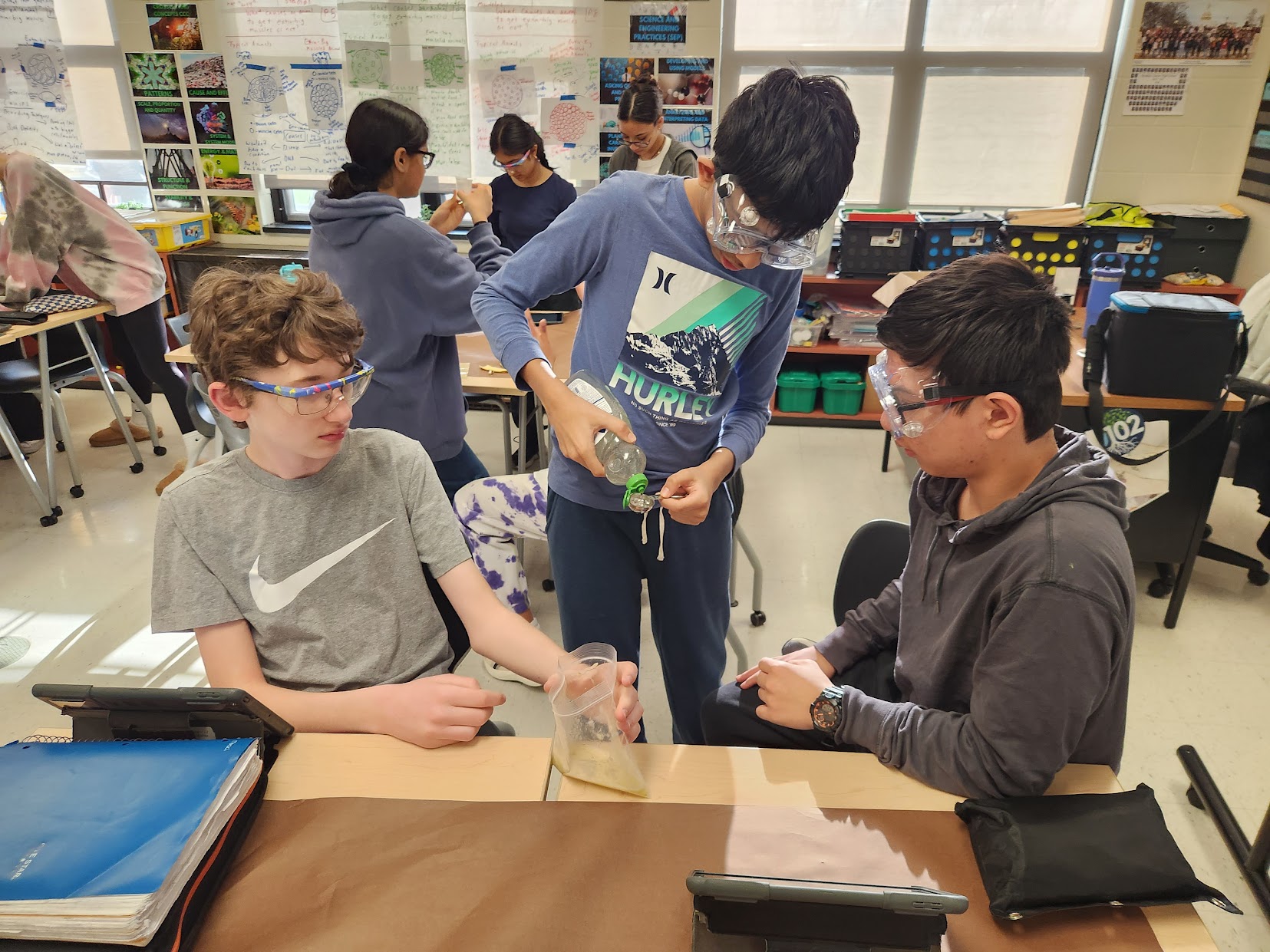 Three 8th graders work on a  science experiment