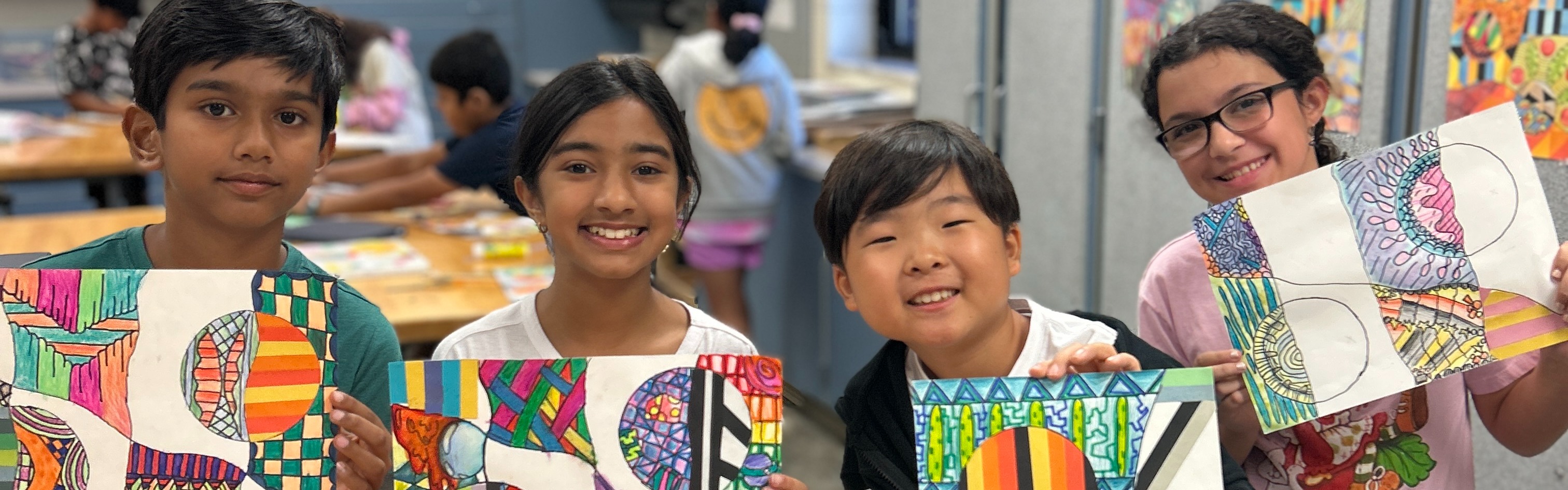 Students holding up their works of art.