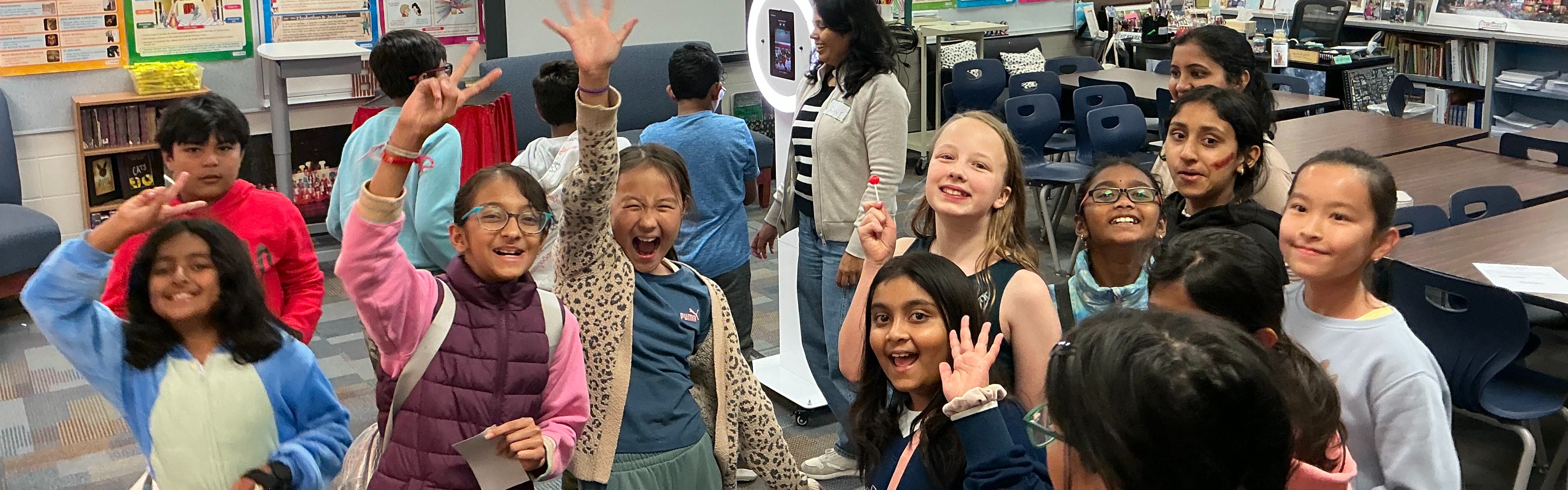 Students smiling with their hands up.