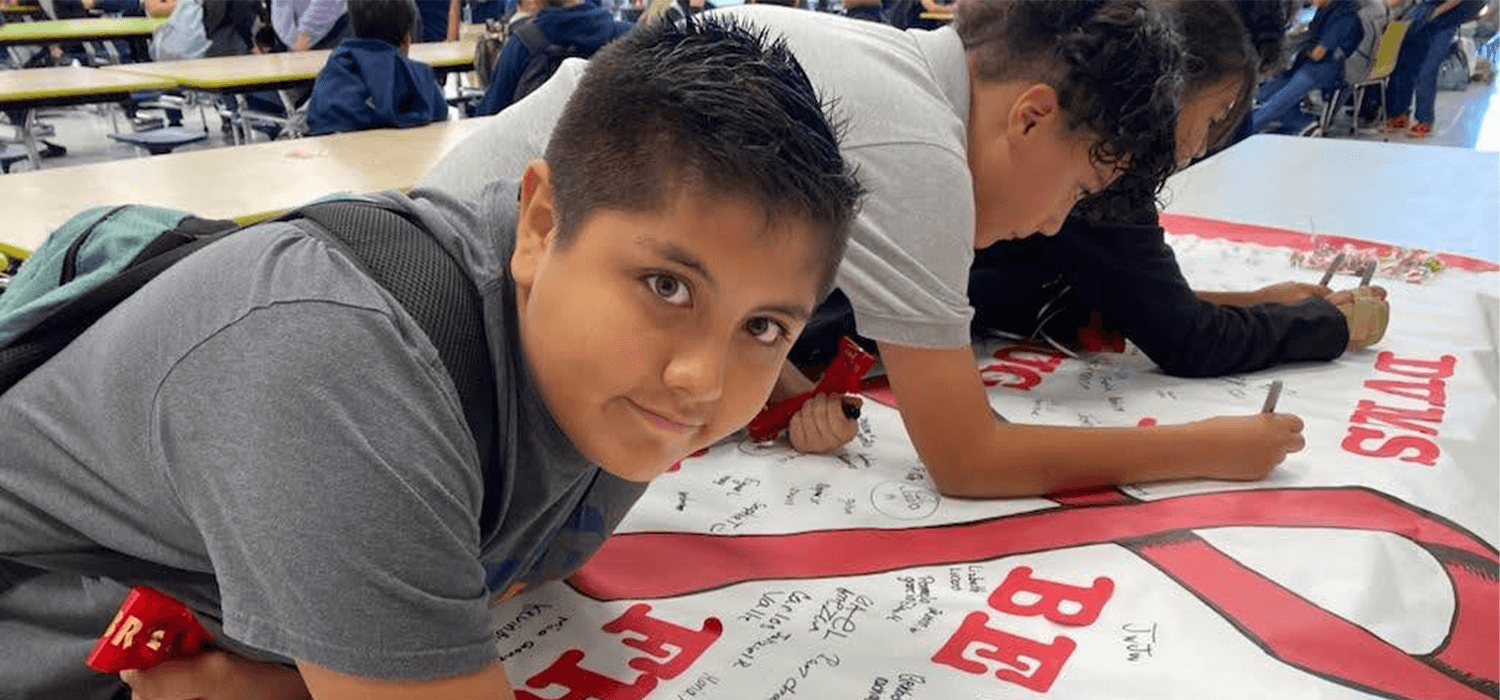 Signing poster in support of Red Ribbon 