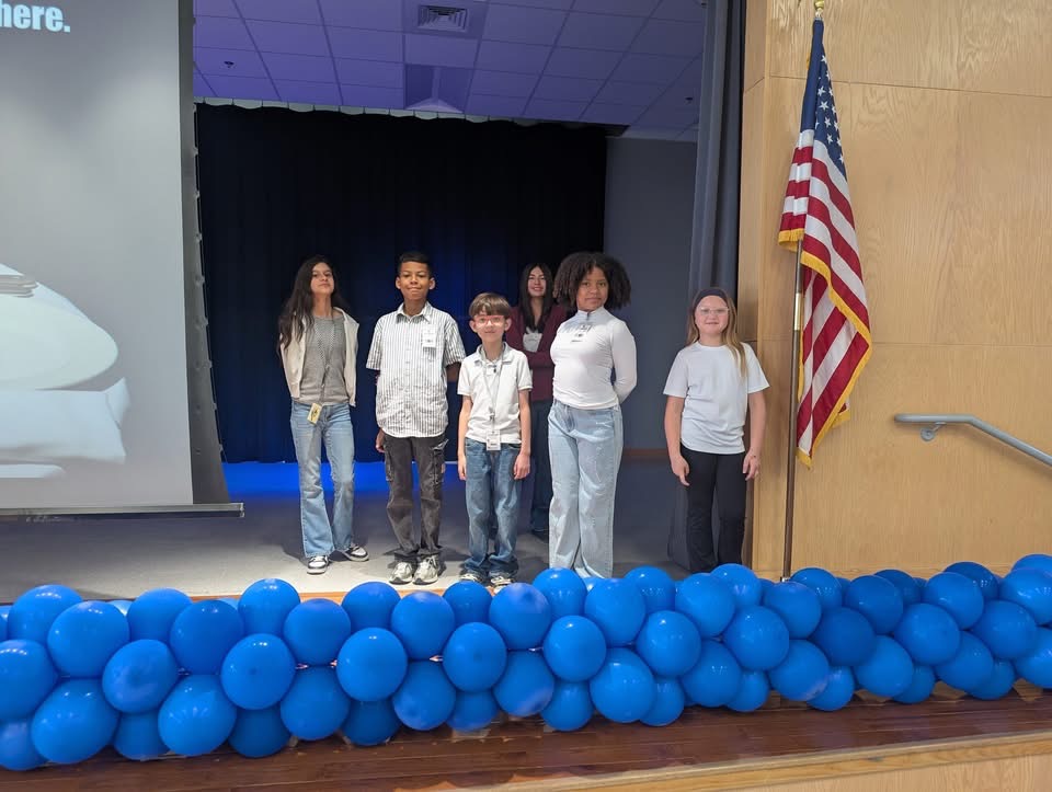 Students are standing by the US flag.