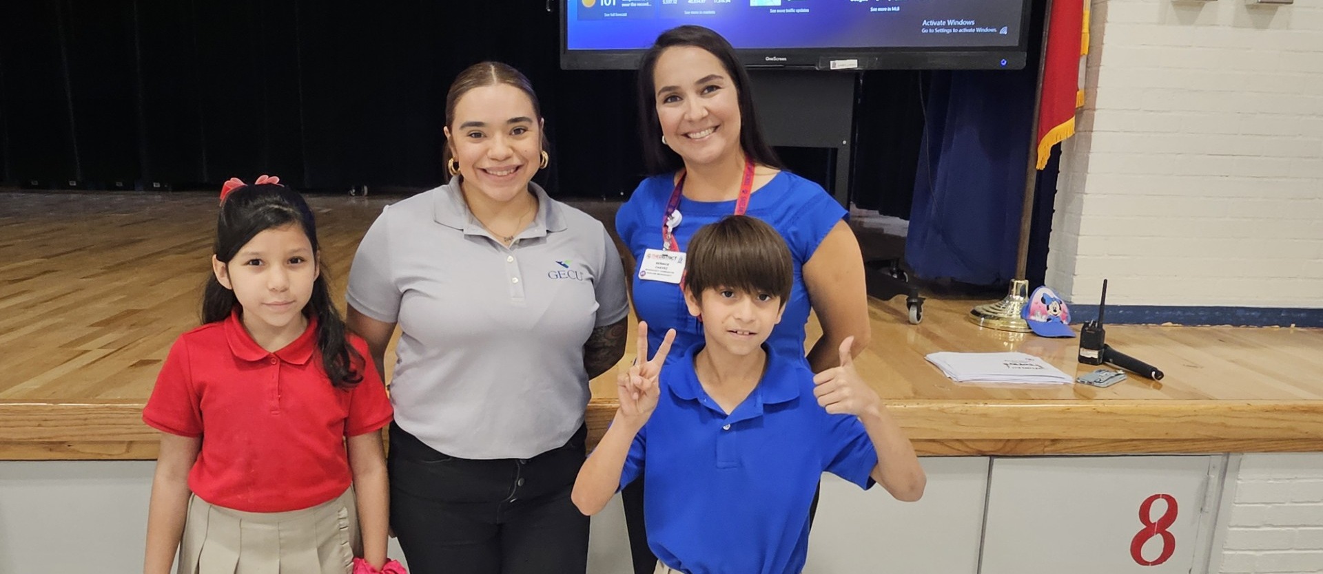 one boy and one girl pose for a photo next to Mrs. Chavez and Mrs. Brianna from GECU (partner's in ed)