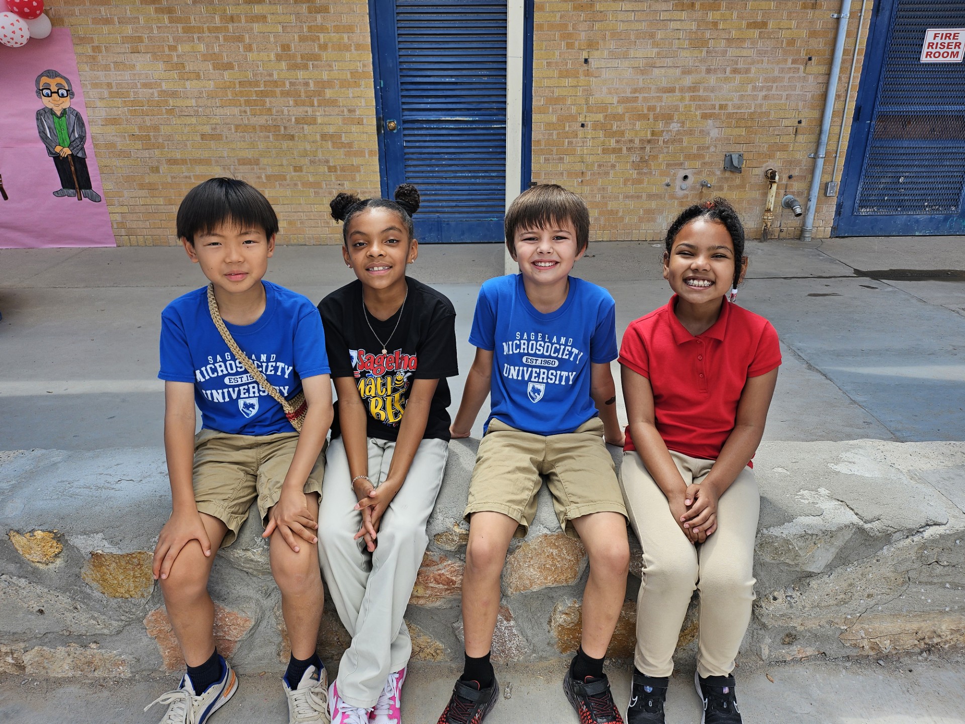 two girls and two boys at recess time sitting outside 