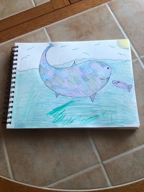 A whale and a fish depicted on a table in a drawing.