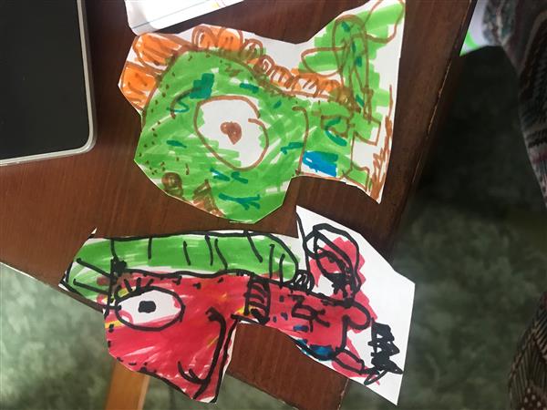 Two children's drawings on paper with a phone - a colorful masterpiece and a doodle of a phone.