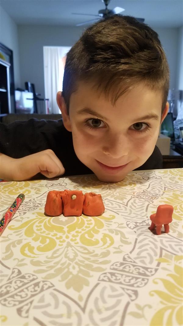 A joyful boy happily engages with a collection of plastic animals, radiating a bright smile.