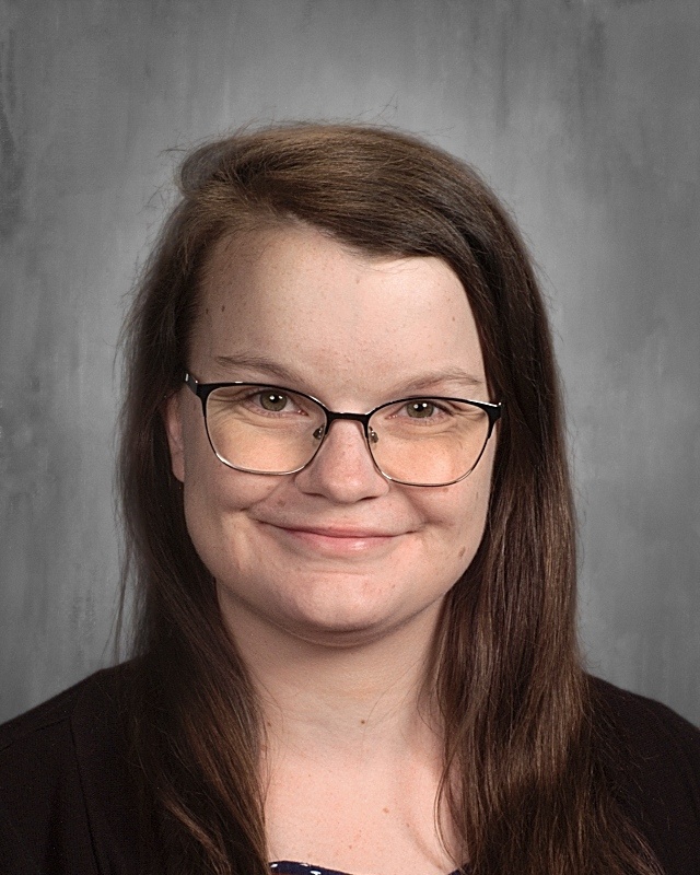 A lady with long black hair wearing eye glasses.