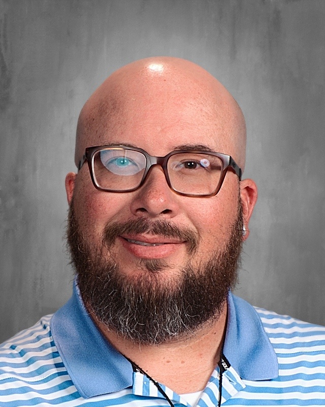 A bald guy with a beard wearing eye glasses.