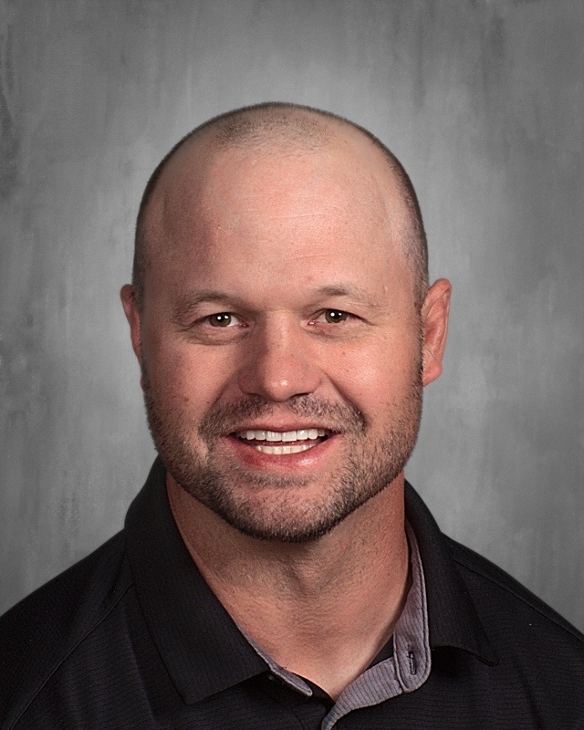 A bald guy wearing black polo shirt.