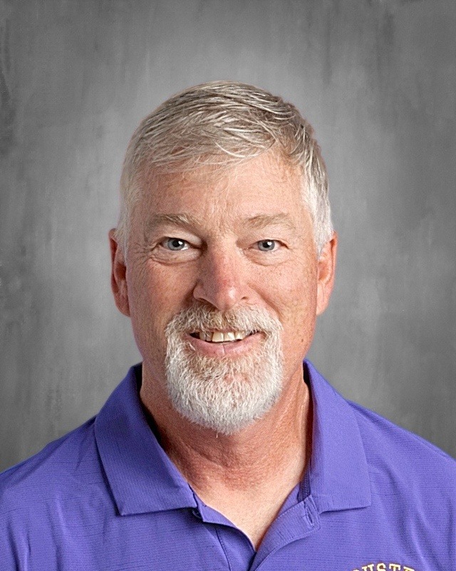 A guy with a beard wearing blue shirt.