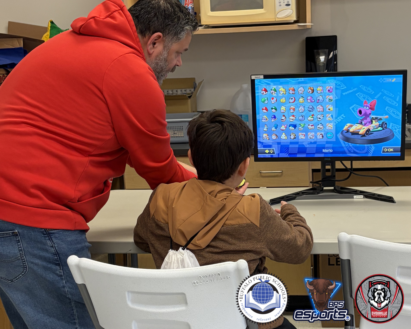 Un niño pequeño es ayudado por un hombre adulto que juega a un videojuego en un ordenador.