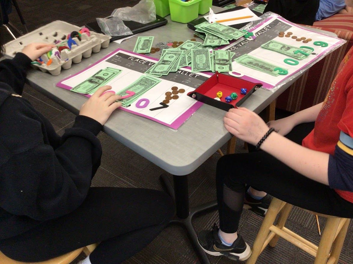 students playing play money on a table