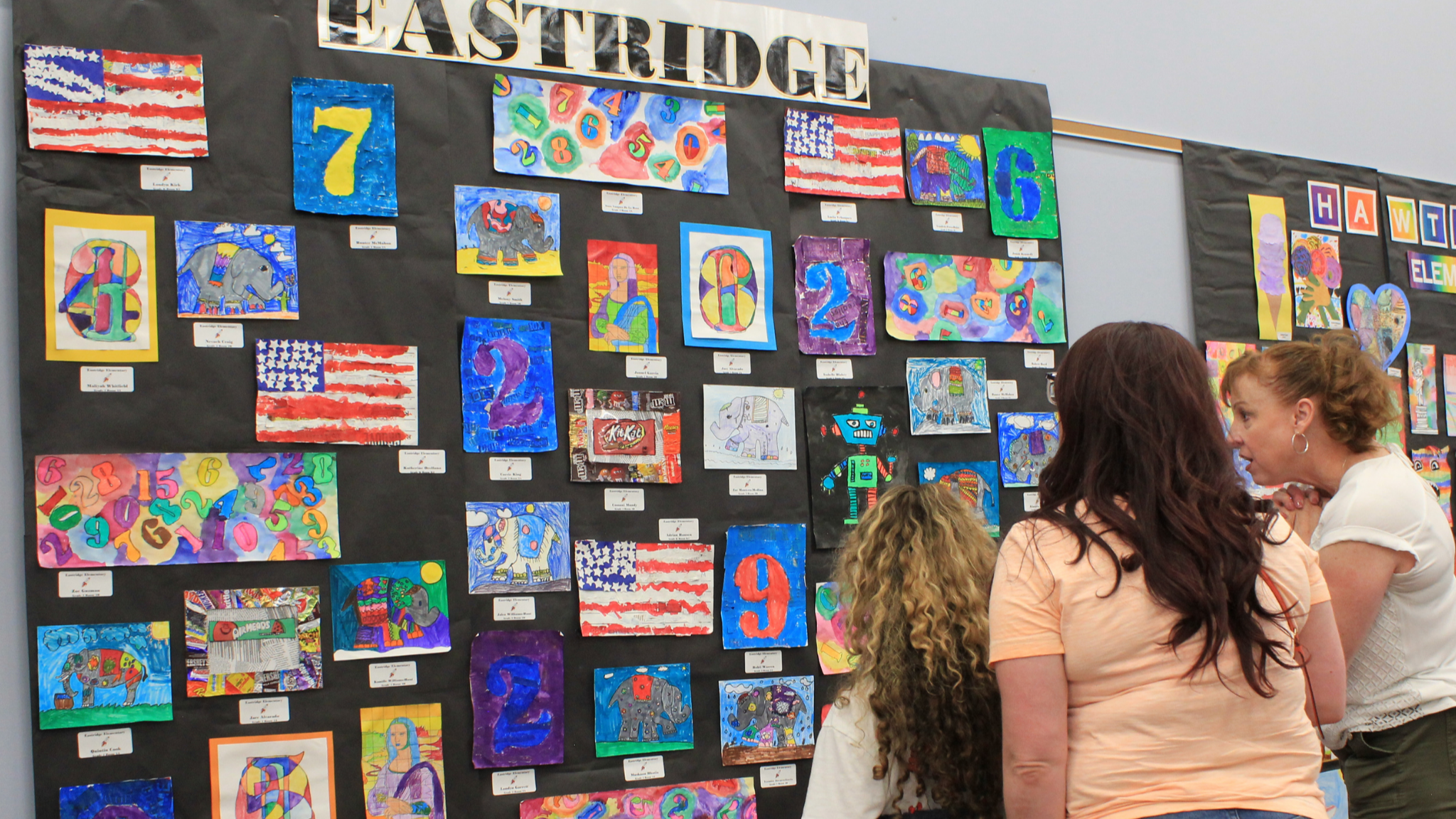 Mother, daughter, and teacher interact at Elementary Art Show