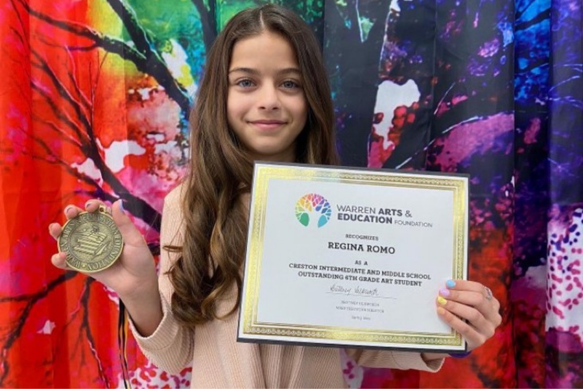 Little girl holding an award she received at school
