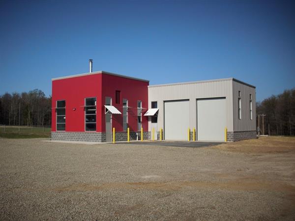 A building with two garages and a red wall.