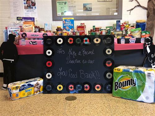 A table with a chalk board and various kinds of foods