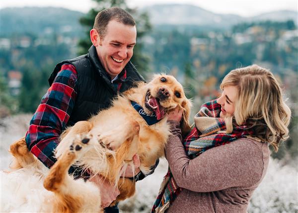 two persons petting a dog
