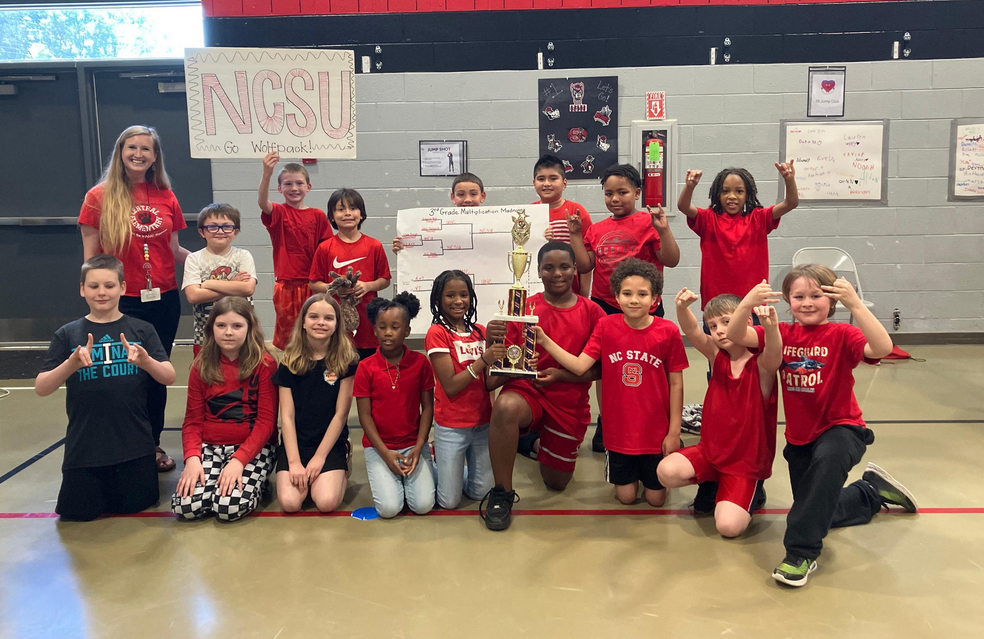 third grade class holding their posters to represent their team in Multiplication march madness