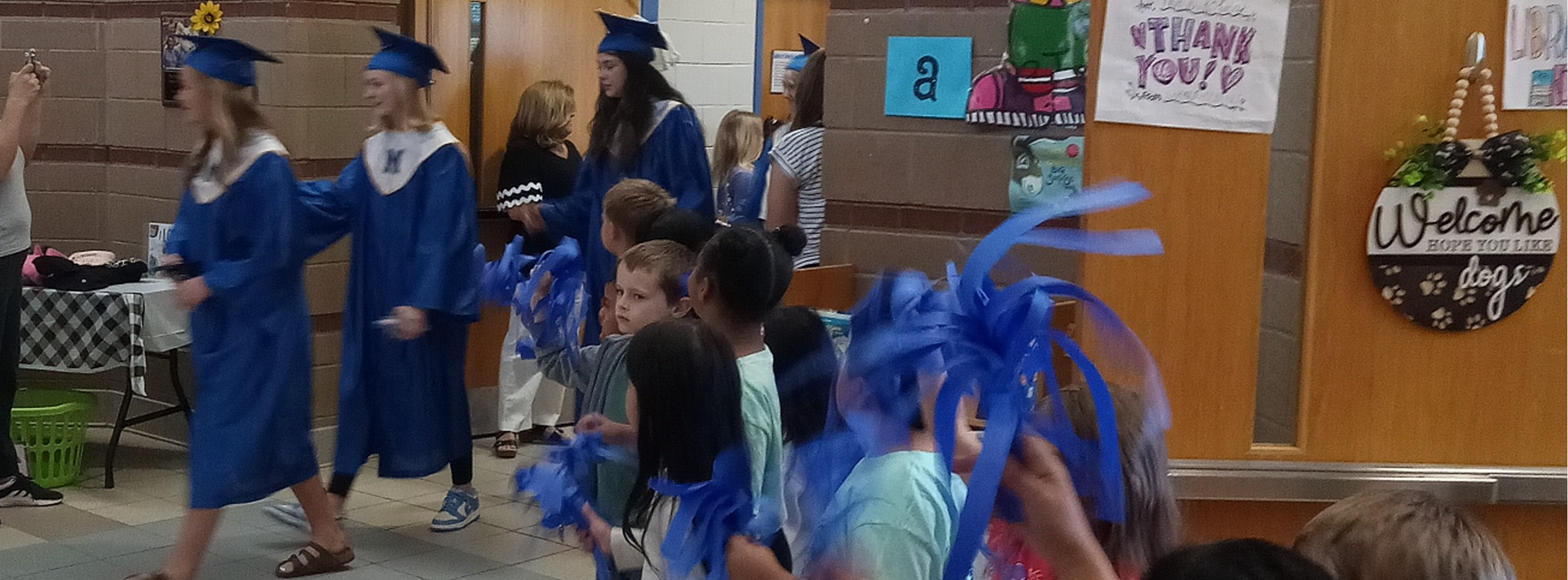 graduates in caps and gowns walking down hall