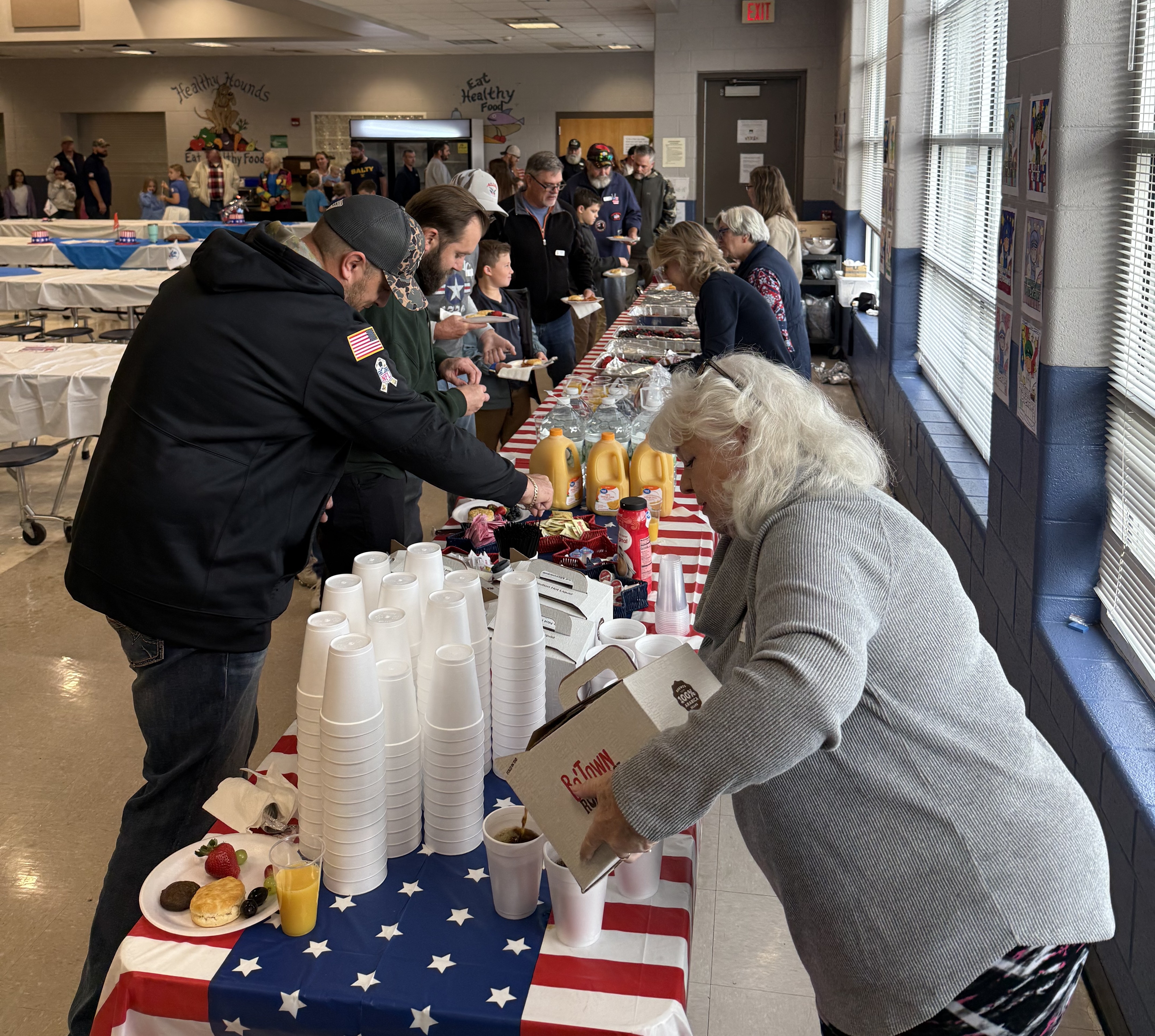 adults serving food to veterans