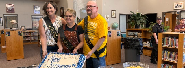 three people holding cake