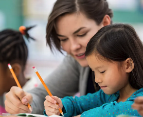 teacher helping to a student writing down