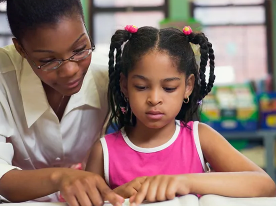 teacher helping a student read
