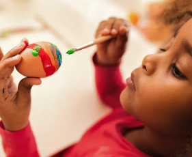 child painting on an egg